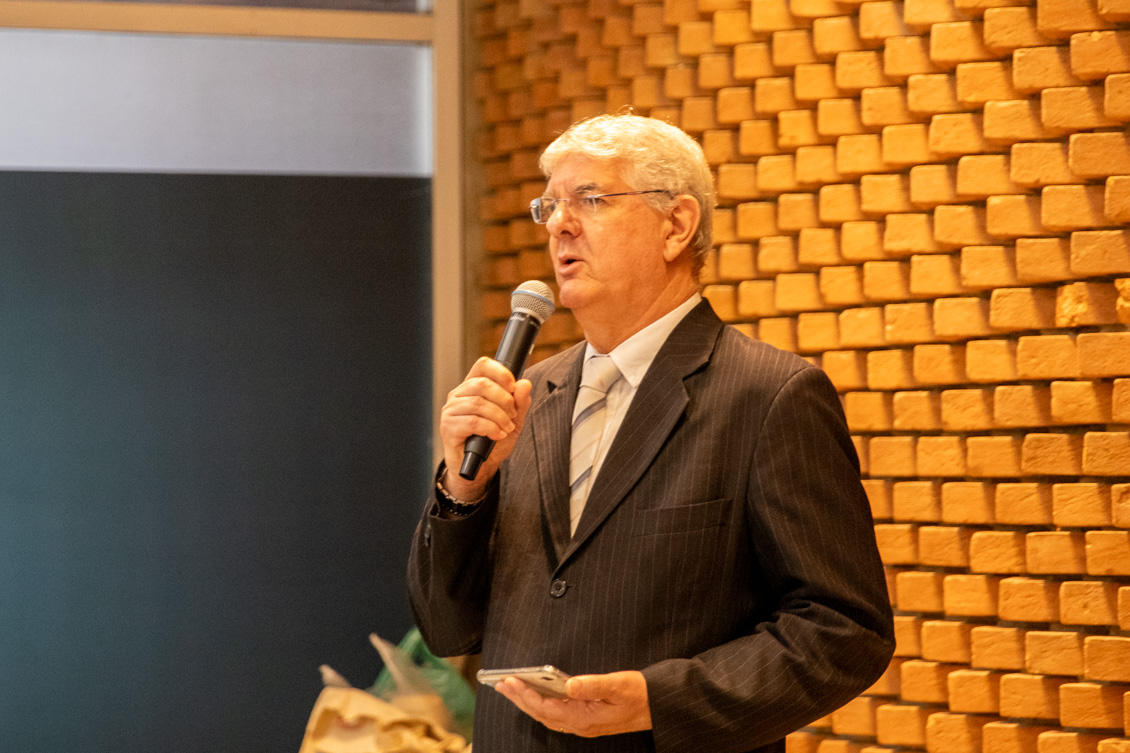 "O magistrado Pelegrini fala ao microfone em pé"