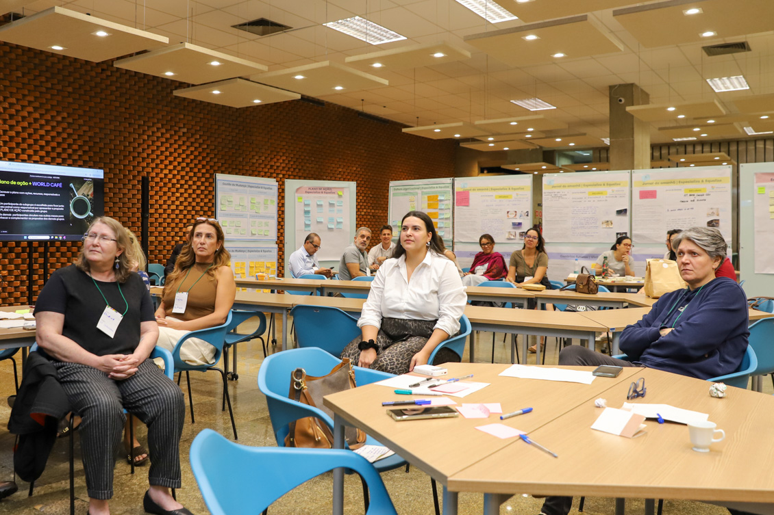 "Diretores estão sentados à mesa no Co.Labora 15, divididos em grupos"