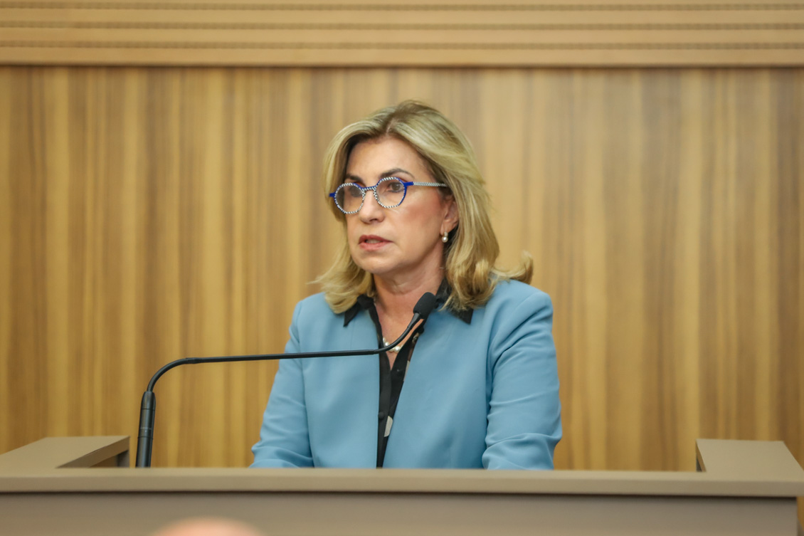 "Desembargadora Ana Paula fala ao microfone no púlpito"