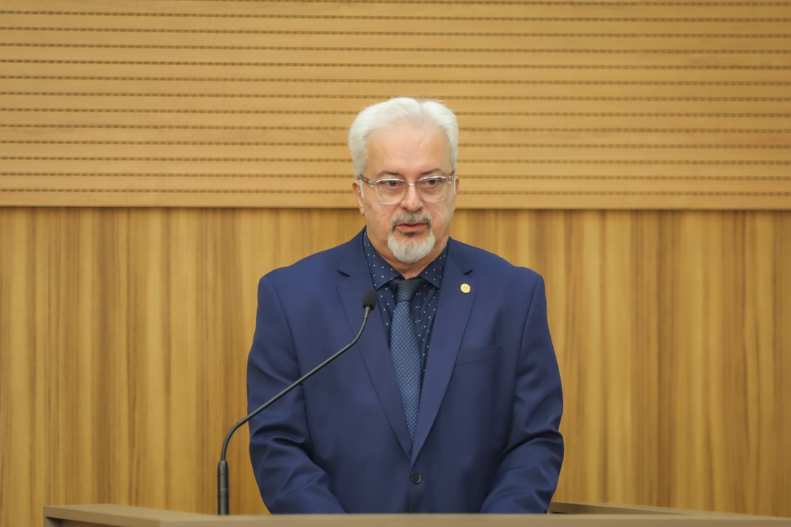 "Dr. Luiz Lobo fala ao microfone no púlpito"