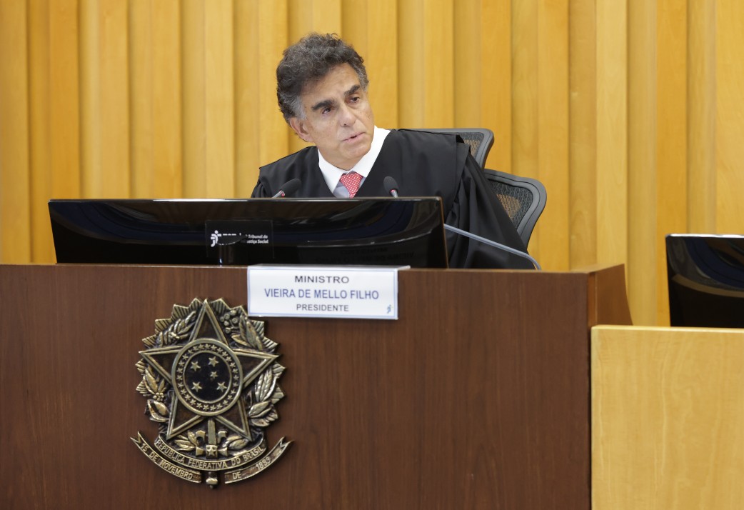 "Ministro Vieira de Mello fala ao microfone, na mesa de abertura do Ano Judiciário"