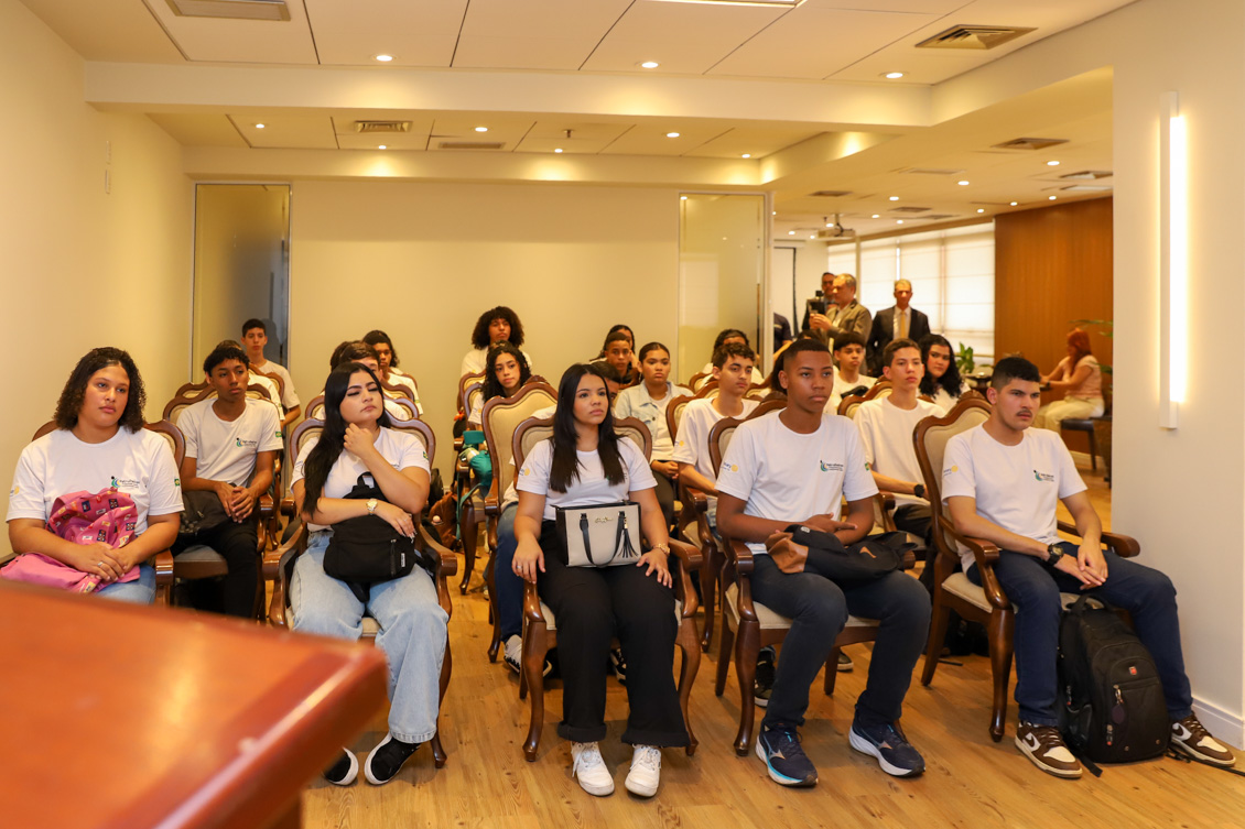 "Aprendizes estão sentados nas cadeiras do Salão Nobre, observando as autoridades"