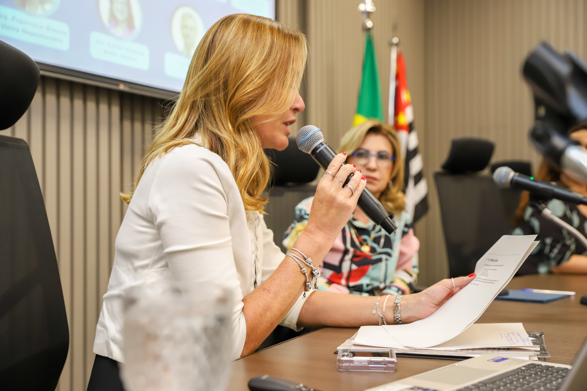 "Dra. Daniela segura o microfone ao ler parte da II Carta Campinas, sendo observada pela Dra. Ana Paula"