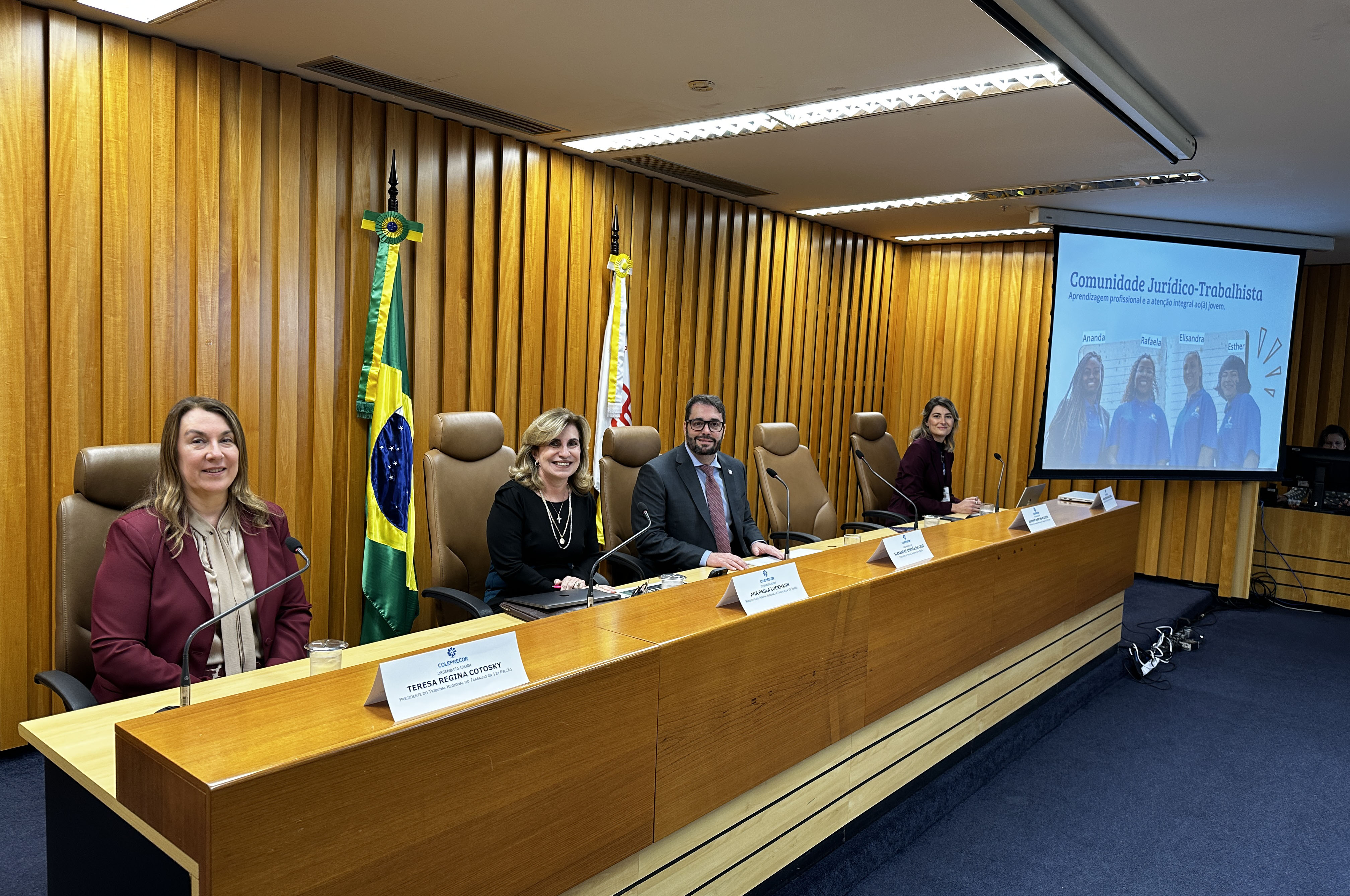 "Representantes dos TRTs estão à mesa de trabalhos para a apresentação"