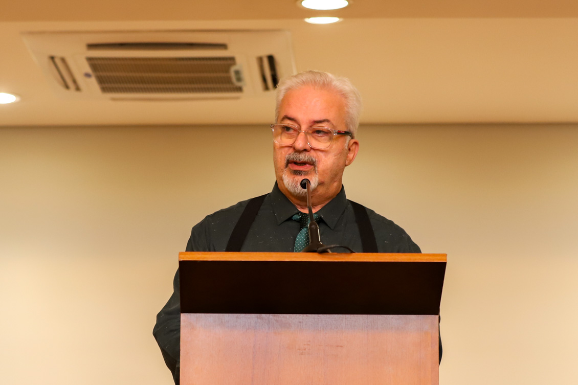 "Dr. Felipe Lobo fala ao microfone no púlpito"