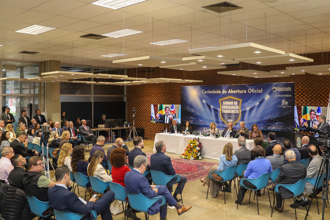 "Co.Labora 15 lotado na abertura da semana, com o ministro no púlpito e mesa de autoridades ao fundo"