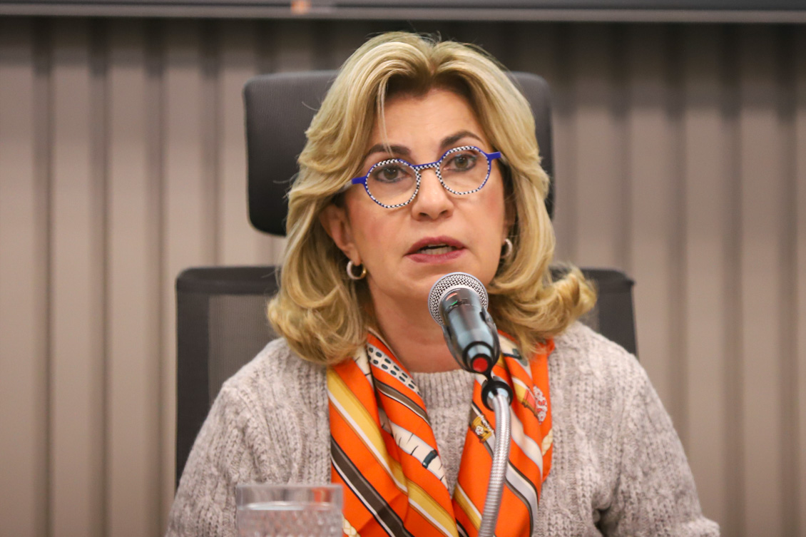 "Dra. Ana Paula fala ao microfone"