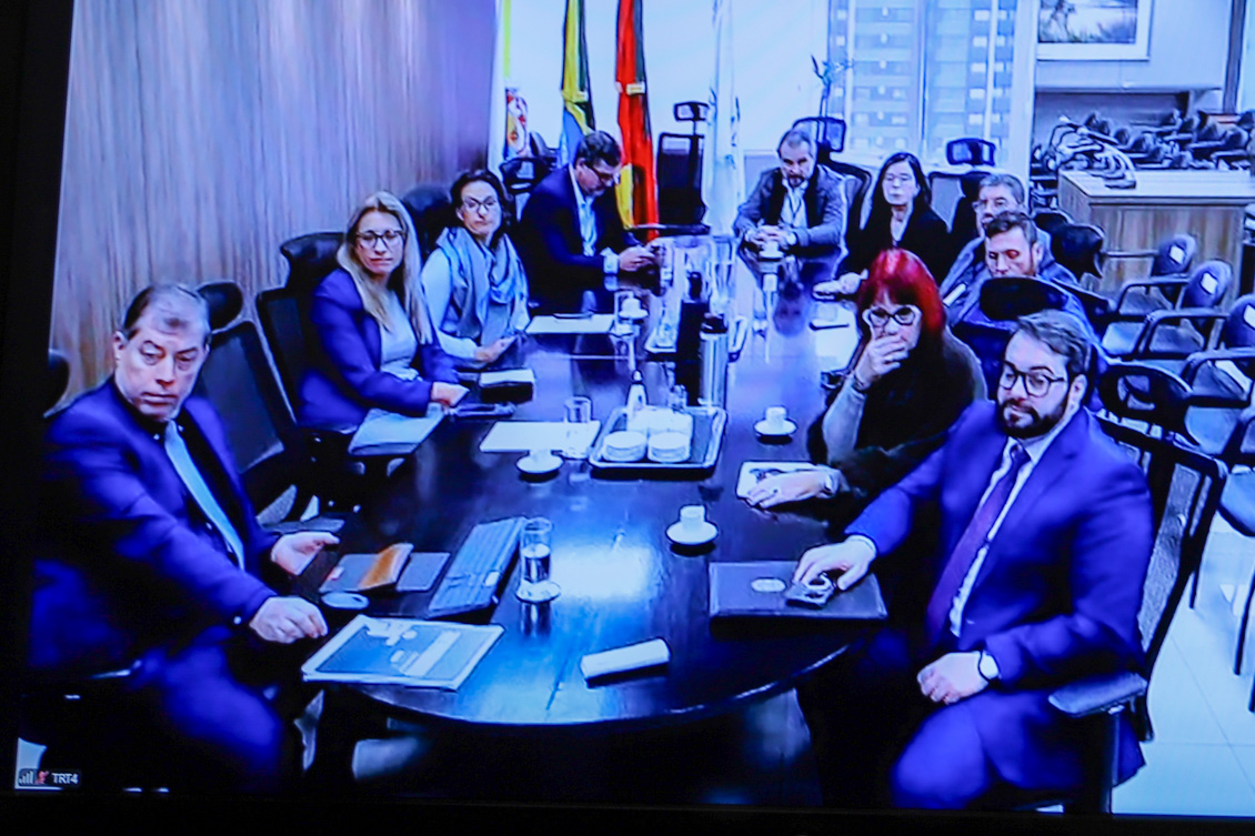 "presidente do TRT-4 e equipe acompanham audiência virtualmente em sala de reunião"