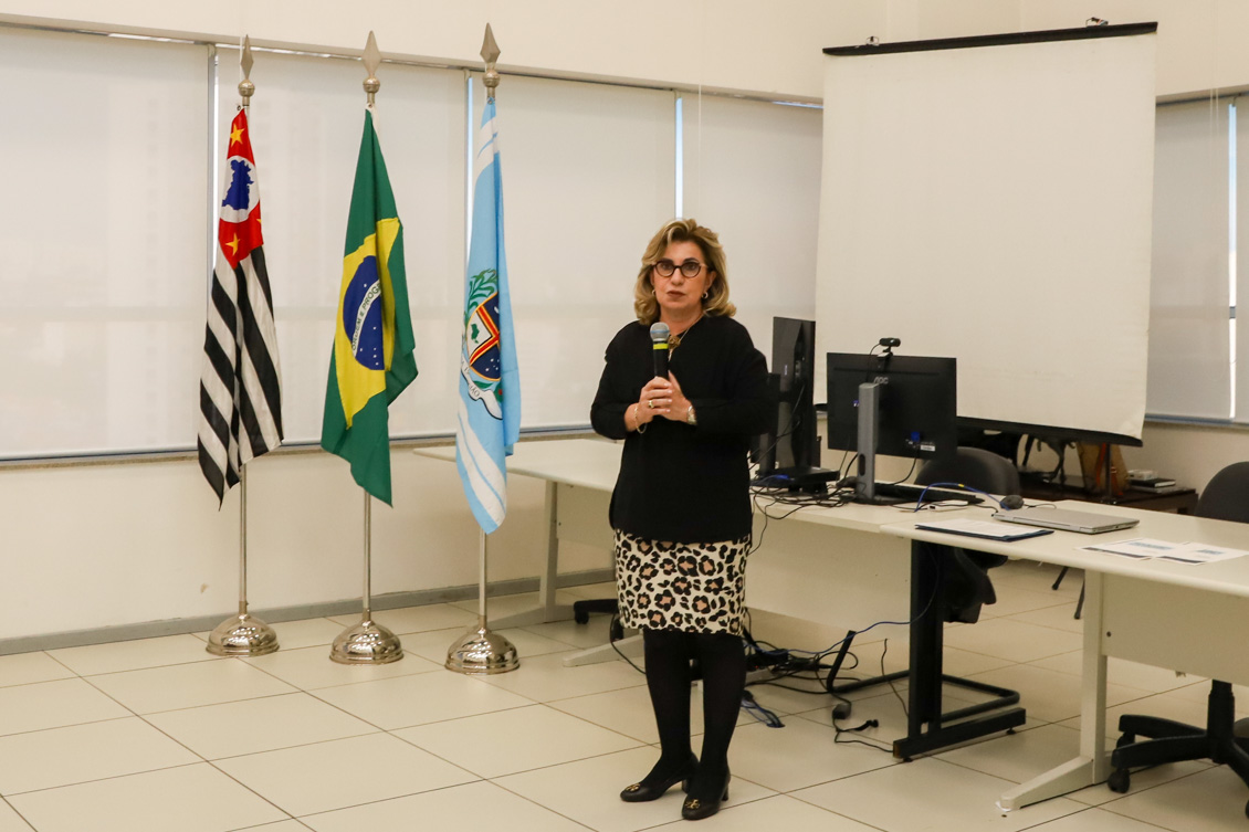 "A presidente Ana Paula fala ao microfone em pé"