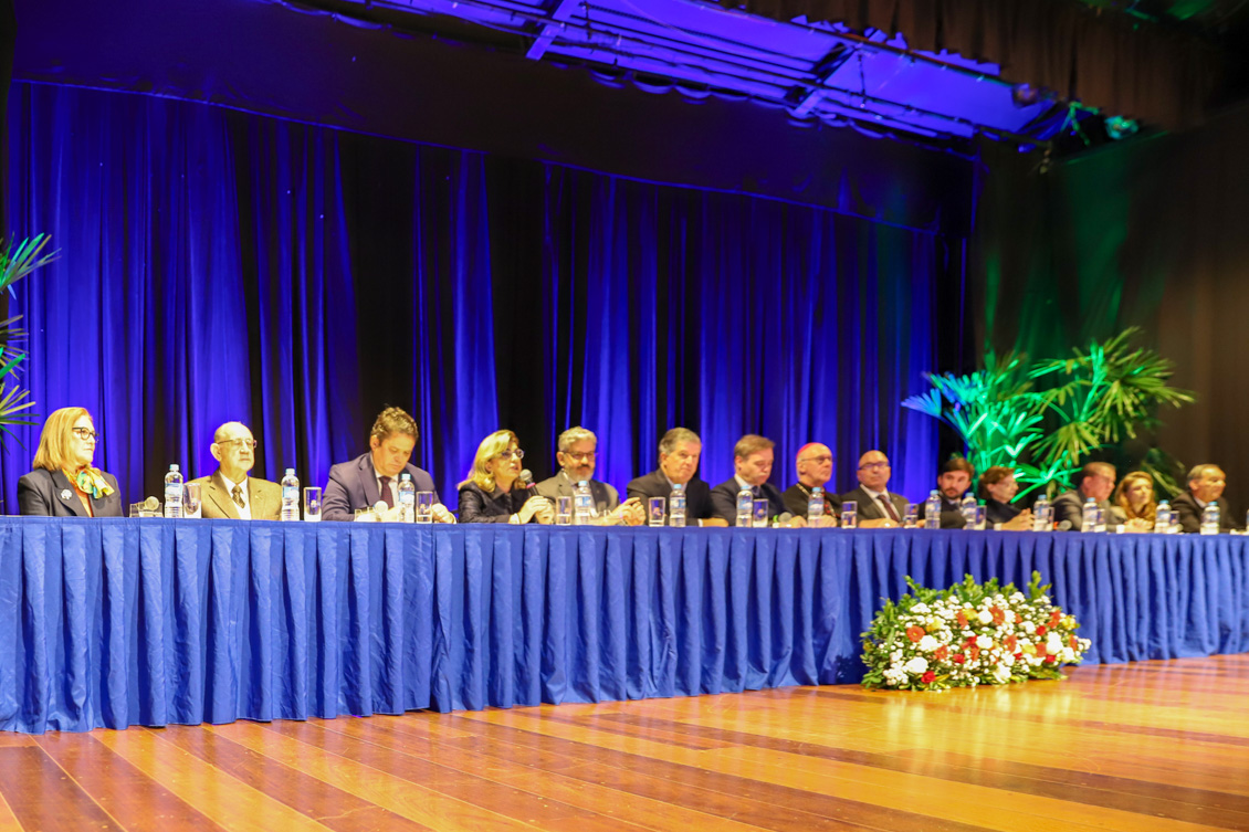 "presidente ana paula discursa na abertura do evento, compondo a mesa alta, acompanhada dos demais integrantes"