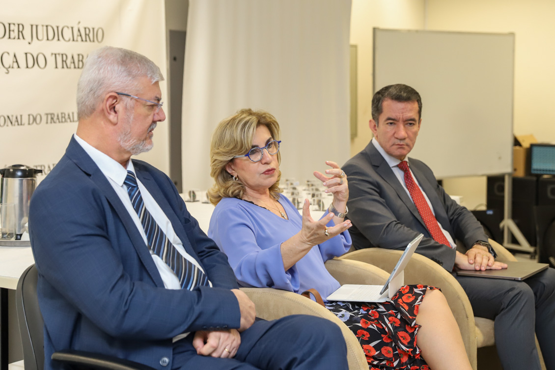 "Desembargadora Ana Paula está sentada ao lado de Edison Pelegrini e Renan Fagundes presidindo a mesa de trabalhos"
