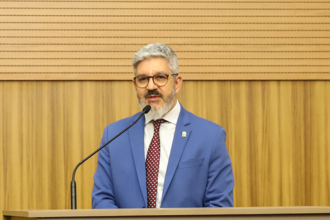 "Secretário Peter Panutto fala ao microfone no púlpito"