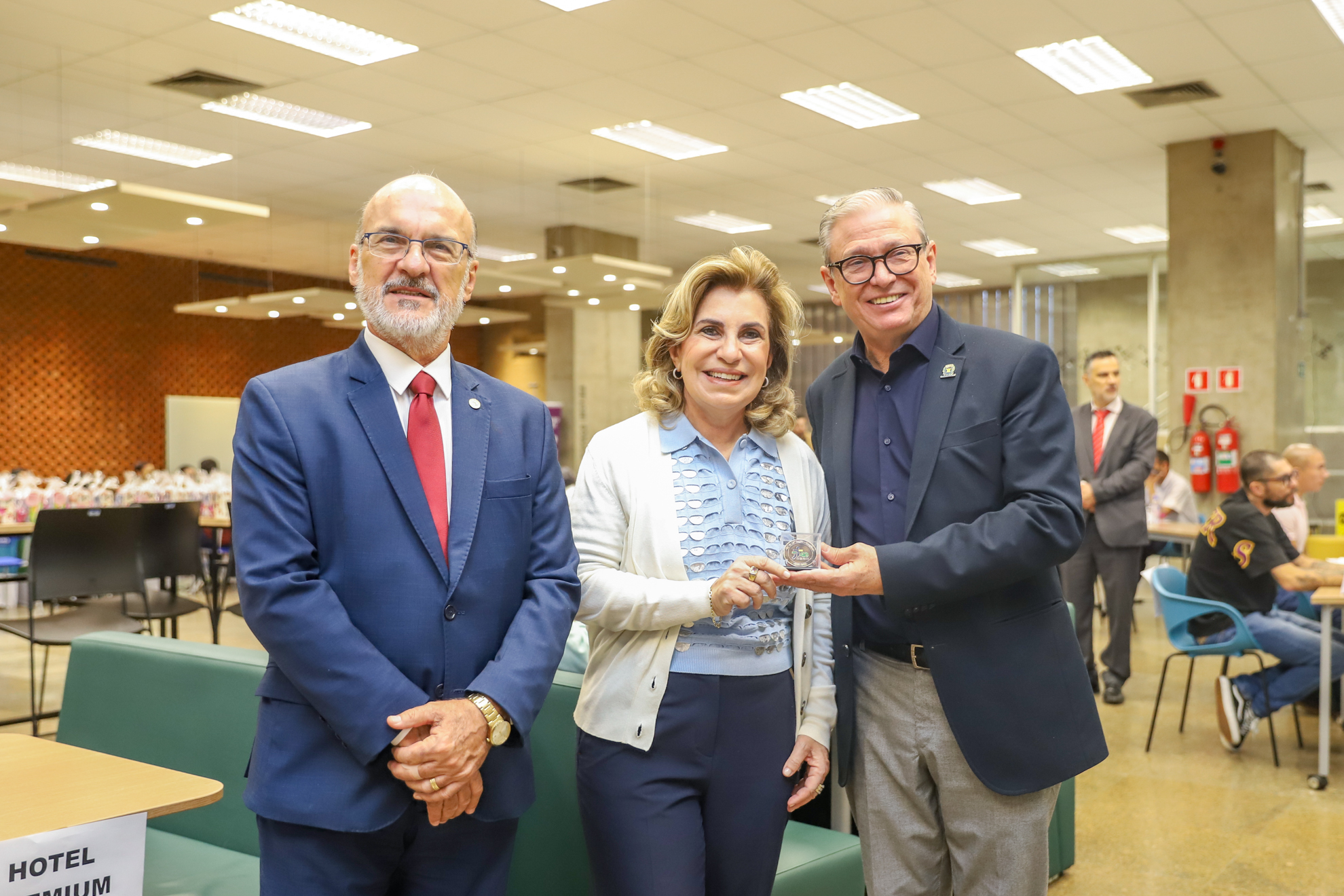 "Dr. Edmundo, Dra. Ana Paula e o secretário Paulo Andrade com a moeda em mãos"