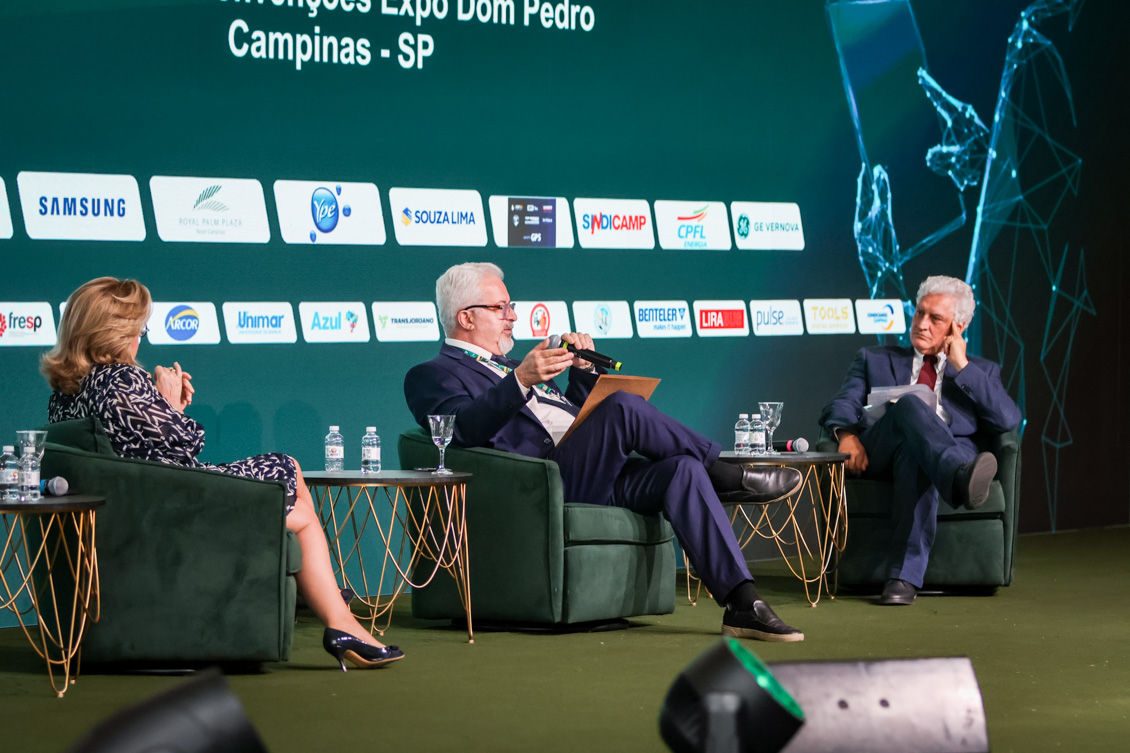 "Três pessoas estão sentadas, dois homens e uma mulher"