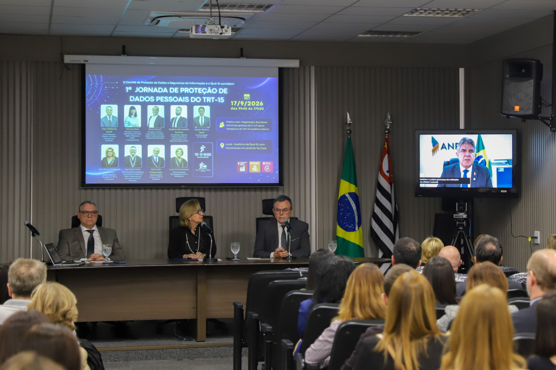 "Na televisão uma autoridade fala de forma teleprensencial sendo observado pelos participantes"