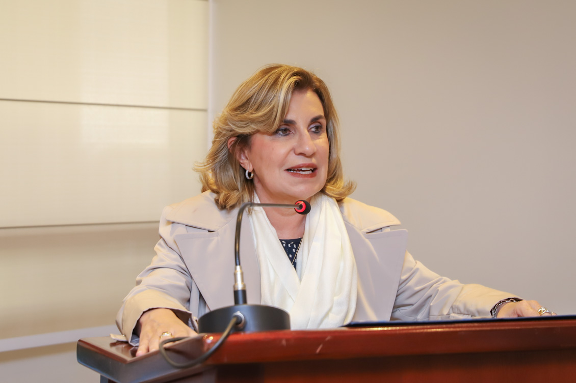 "A presidente Ana Paula fala ao microfone no púlpito"