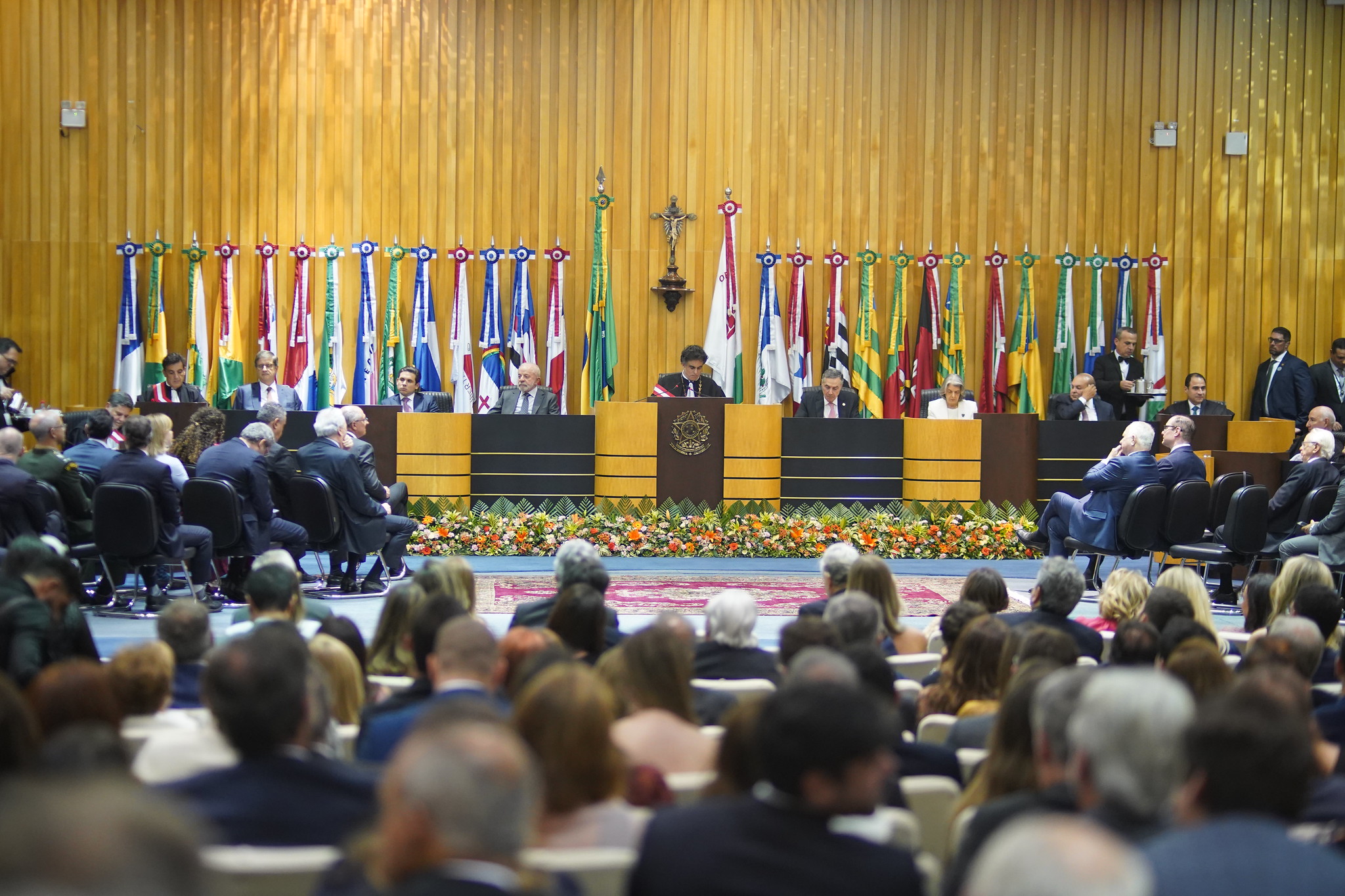 "imagem geral do plenário com mesa alta composta pelo presidente Lula, pelo presidente Luiz Philippe e demais autoridades, sendo observados pelo público"