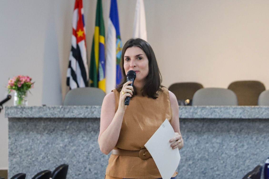 "juíza coordenadora do Cejusc, Andressa Weber falando ao microfone"