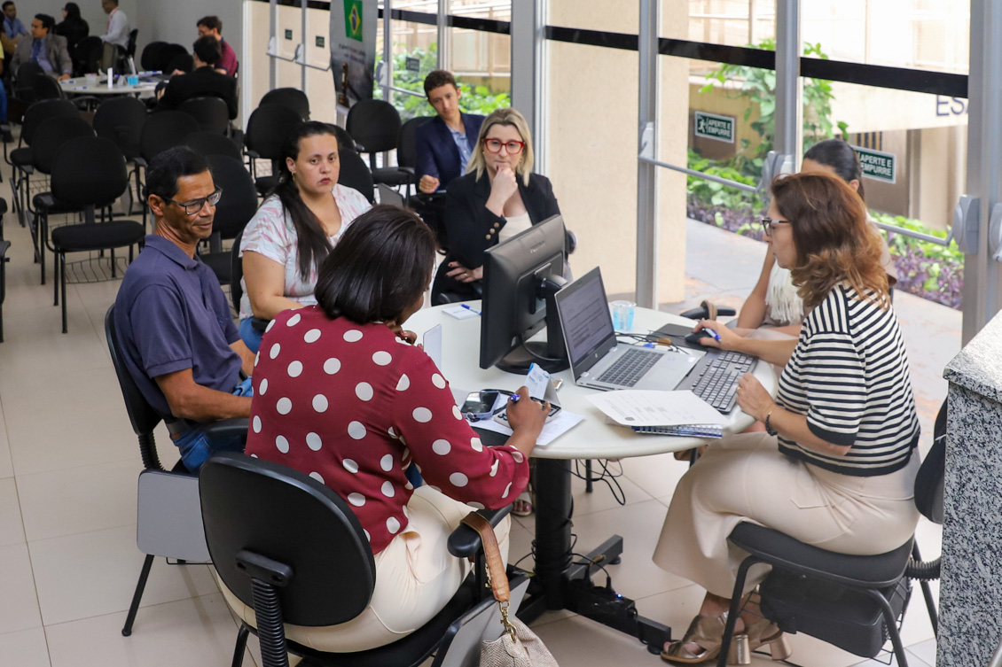 "cinco mulheres e um homem sentados em uma mesa redonda de conciliação trabalhista"