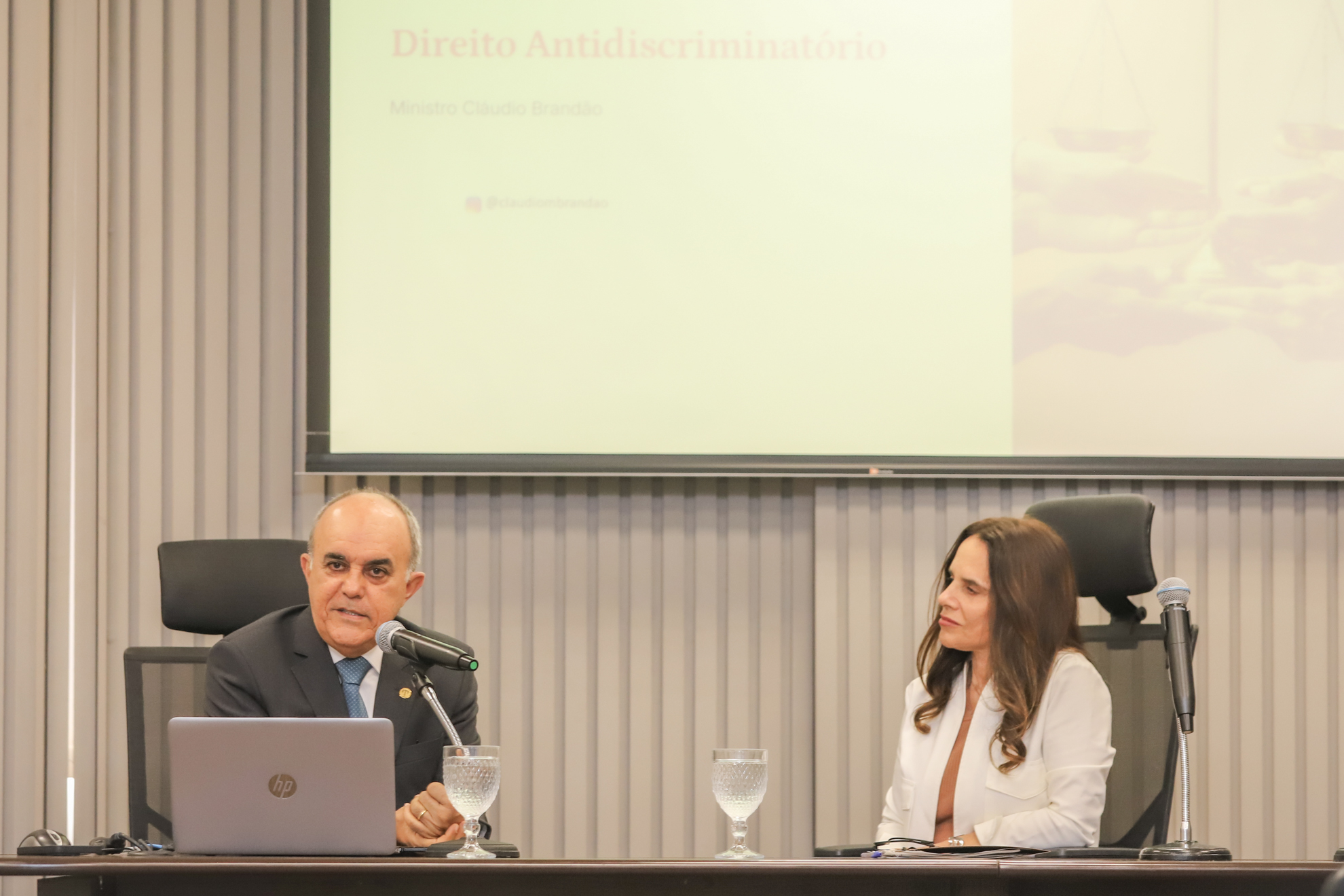 "desembargadora Adriene Sidnei de Moura David e ministro Cláudio Brandão falam ao microfone"