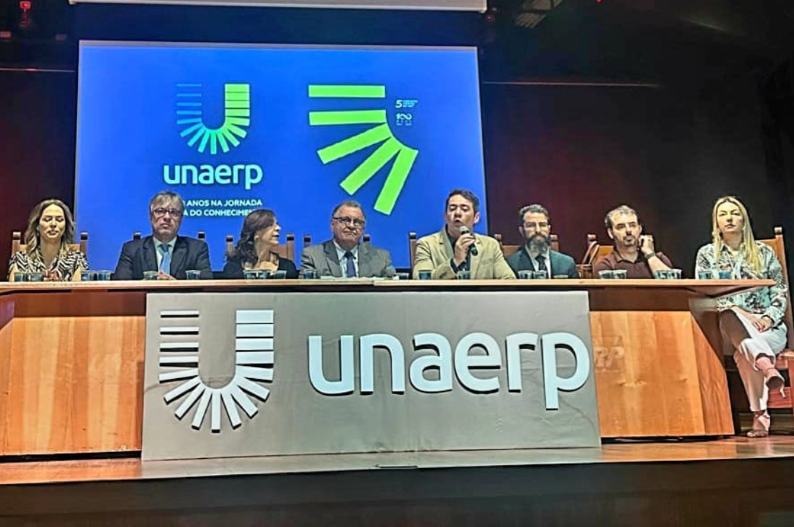 "imagem da mesa com5 homens e  três mulheres sentados"