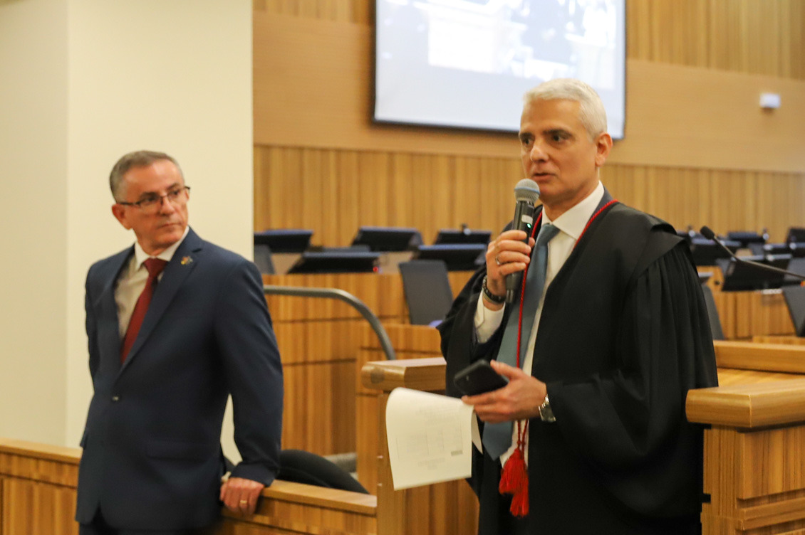 "vice-procurador chefe do trabalho substituto, Fábio Messias Vieira fala ao microfone, ao lado do desembargador"