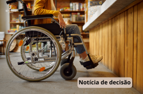 uma mulher está em ambiente de trabalho utilizando cadeira de rodas