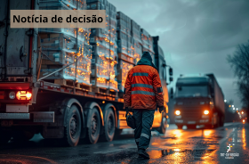 estrada ao anoitecer com um funcionário andando entre caminhões carregados de mercadoria