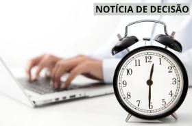 imagem de mãos trabalhando em um computador e um relógio em primeiro plano