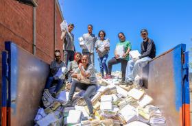 #ParaTodosVerem: pessoas posam para foto sobre uma pilha de processos