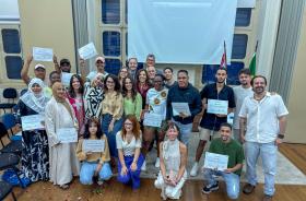 imagem de um grupo de pessoas posando para foto com certificados nas mãos