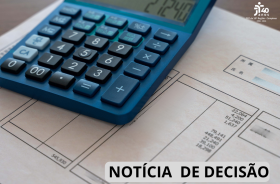 Uma calculadora azul repousa sobre documentos com tabelas e valores, remetendo a cálculos financeiros ou contábeis.