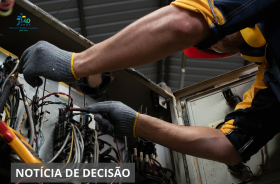 Imagem retrata a mão de uma pessoa mexendo na rede elétrica.