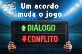 campo de futebol com placa indicando substituição do conflito pelo diálogo e os dizeres: um acordo muda o jogo