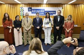 foto posada da Dra. Ana Cláudia com o certificado em mãos, ao lado do ministro Caputo Bastos e outras cinco pessoas