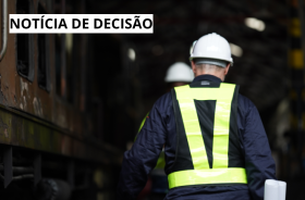 Banner retrata um empregado usando EPIs andando de costa entre duas locomotivas