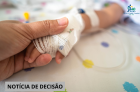 #ParaTodosVerem: mão adulta segura a mão de um bebê, que está sendo medicado