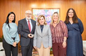 foto posada da Dra. Ana Paula com Luiz Costa segurando a medalha, acompanhados de Karina as advogadas Marcela e Simone