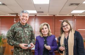 Duas mulheres e um homem posam para a foto.