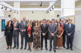 Os homenageados posam para a foto em pé, atrás o público que acompanhou o evento.