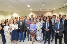foto posada com os membros da alta administração e os juízes segurando as moedas