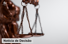 Imagem em formato horizontal, com fundo predominantemente branco. Em primeiro plano, à esquerda, aparece uma representação da estátua da Justiça, em tom bronze, parcialmente desfocada. Ao centro, destaca-se uma balança de pratos em bronze, com correntes e um dos pratos em foco. Ao fundo, outra balança aparece desfocada. No canto superior esquerdo, há o logotipo comemorativo dos 40 anos do TRT da 15ª Região – Campinas, com o período “1986–2026”. Na parte inferior esquerda, sobre uma faixa branca translúcida,