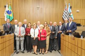 Ex-integrantes da alta administração e membros do MPT-15 posam para foto com a moeda comemorativa em mãos