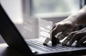 mãos usando um notebook com fichas virtuais saindo do teclado