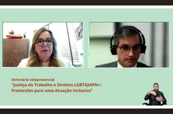 Quadro verde claro com tarjas pretas na parte superior e posterior. Na tela estão a desembargadora Eleonora e o juiz palestrante André Cavalcanti. Abaixo, o nome do seminário e uma pessoa numa pequena janela lateral, fazendo tradução em Libras.