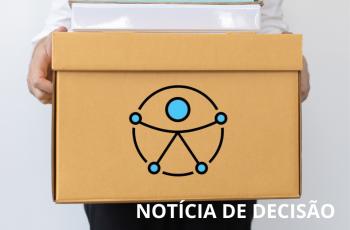 homem segura caixa com itens de escritório. Na caixa, o novo símbolo da acessibilidade.