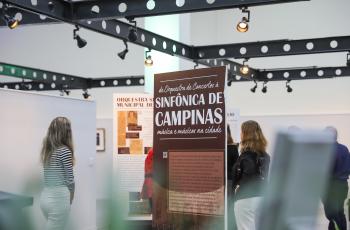 imagem geral da exposição, com os painéis informativos sendo observado pelas pessoas