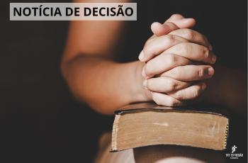 mãos cruzadas de uma mulher sobre uma bíblia
