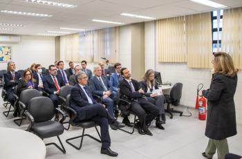 Dra. Ana Paula fala com os magistrados, que estão sentados em cadeiras numa sala do Fórum de Sorocaba