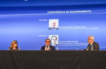 mesa de trabalhos com o ministro ao centro, ladeado pela Dra. Ana Paula à esquerda da tela, e Dr. Luiz Felipe Lobo, à direita.